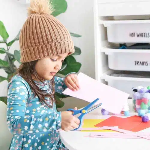 Little girl cutting paper using Kiddies Safety Scissors